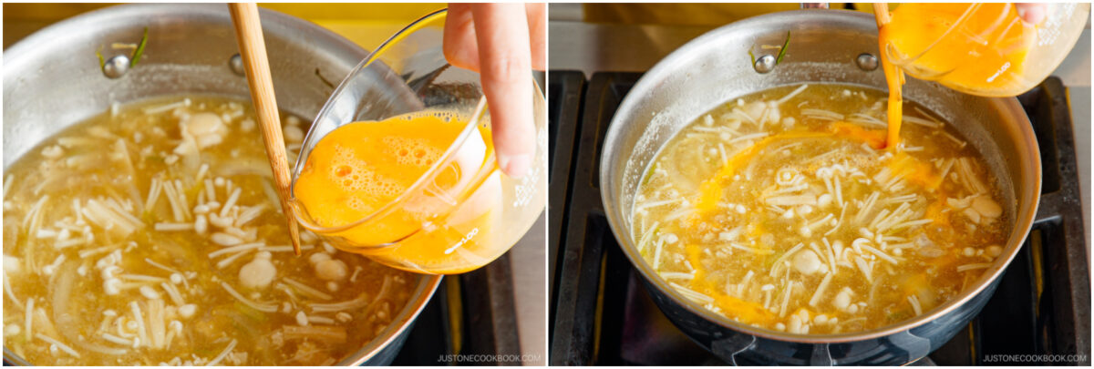 A person pours beaten eggs from a bowl into a pot of soup with sliced mushrooms and noodles, stirring with a wooden spoon on a stovetop.