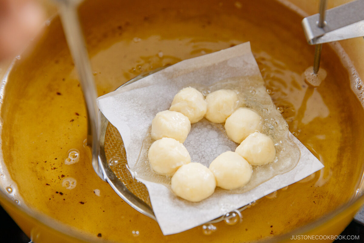 Submerging the donut in the oil.